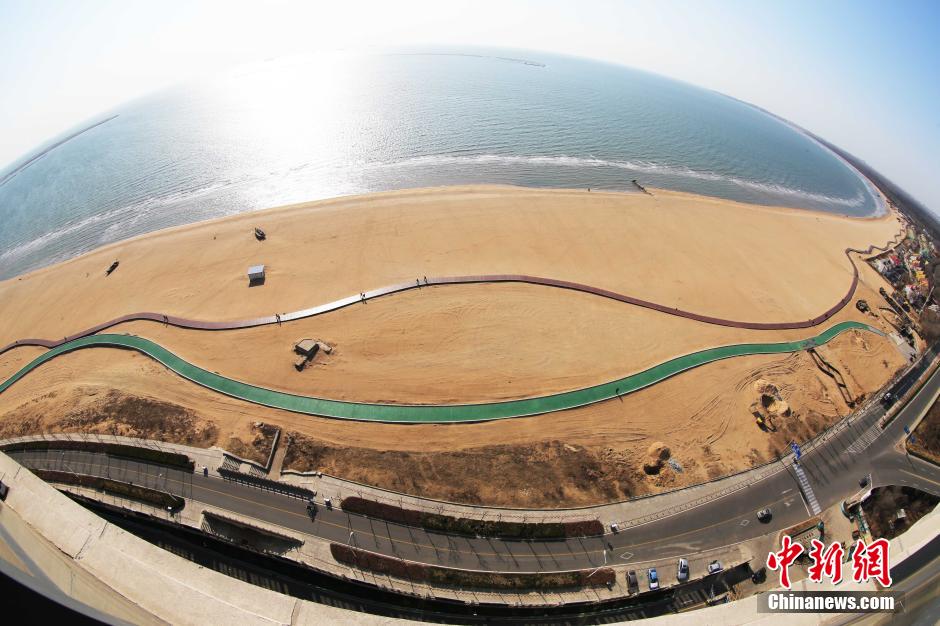 3月13日，秦皇島萬米臨海沙灘木棧道。據(jù)了解，該木棧道全長約4200米，與北戴河區(qū)原有的7500米木棧道對接后全線總長度1.17萬米，整個木棧道東起秦皇島體育基地游船碼頭，西至北戴河濕地公園，呈波浪形蜿蜒10.4公里海岸線。 中新社發(fā) 曹建雄 攝 CNSPHOTO